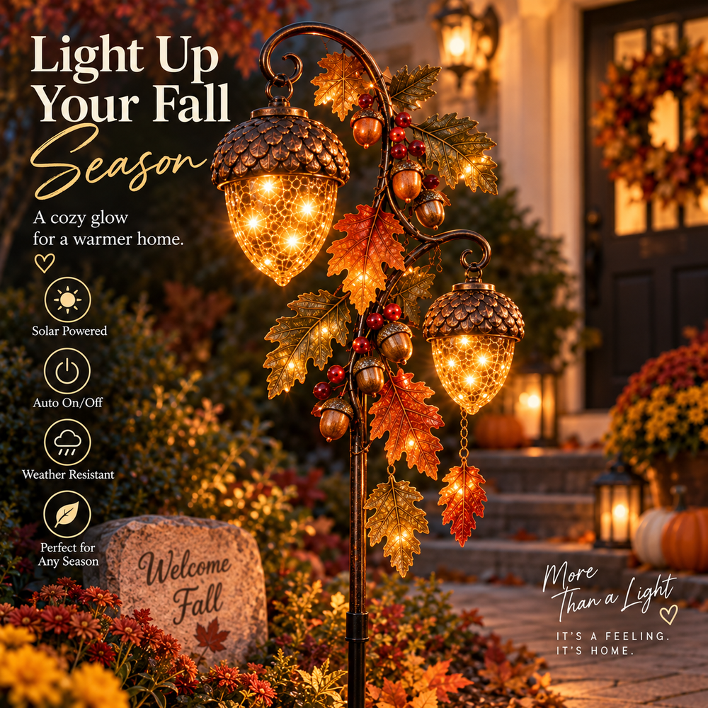Double acorn solar garden stake glowing beside an autumn front porch
